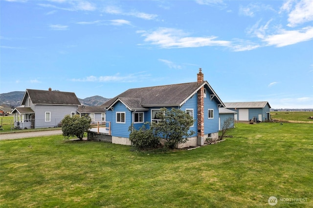 exterior space featuring a yard, driveway, and a chimney