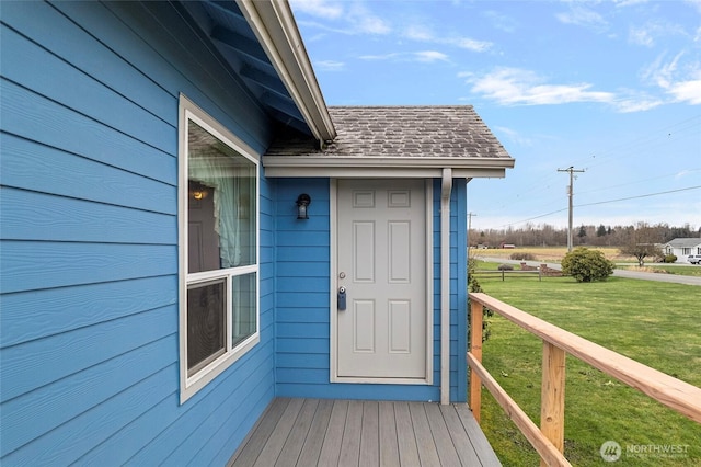 view of exterior entry featuring a lawn