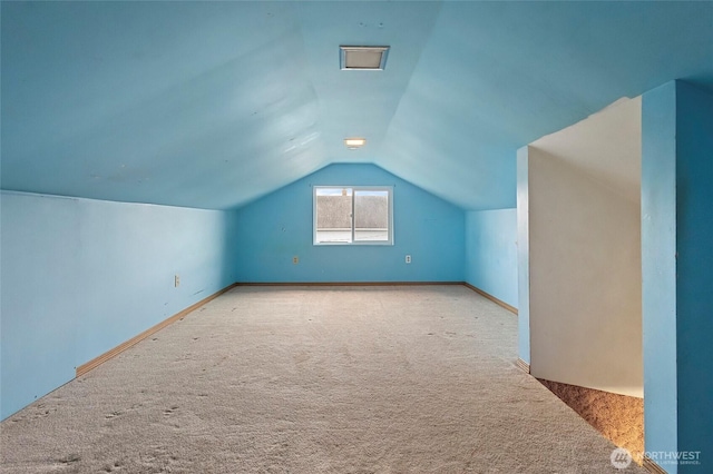 additional living space with lofted ceiling, carpet, and baseboards