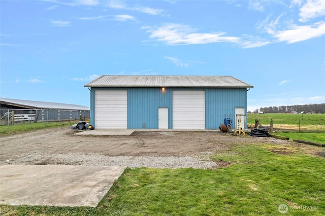 view of pole building with a lawn and fence