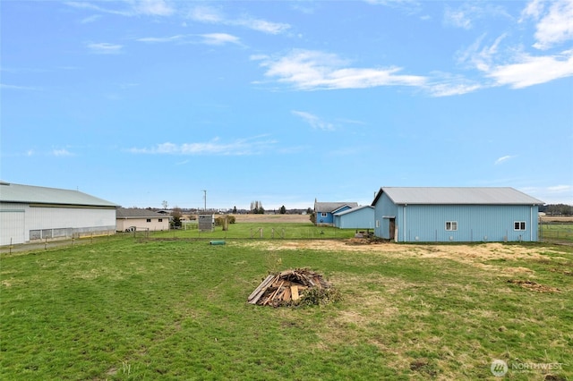 view of yard with an outbuilding, fence, and an outdoor structure