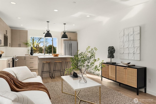 living area with recessed lighting and light wood-style flooring