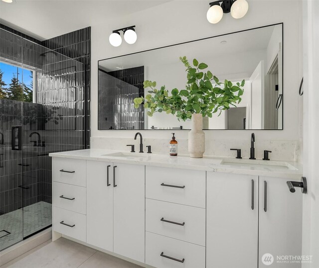 full bath featuring double vanity, a shower stall, and a sink