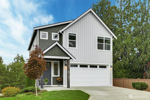 view of front facade with board and batten siding, concrete driveway, a garage, and fence