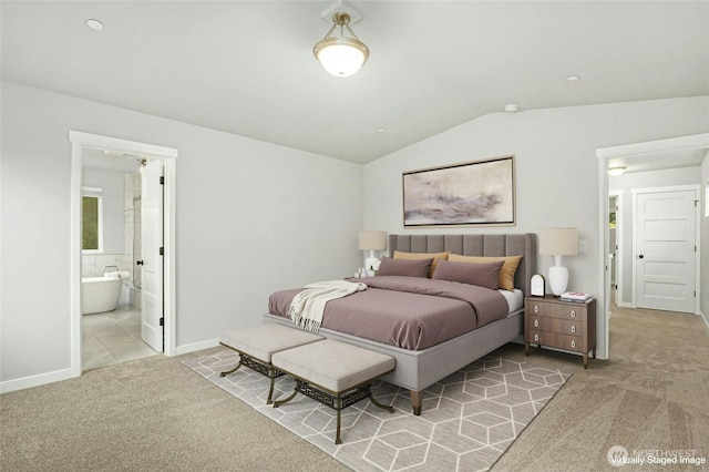 carpeted bedroom featuring connected bathroom, baseboards, and vaulted ceiling