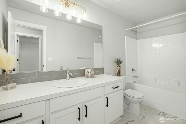 bathroom with vanity, marble finish floor, shower / bath combination, toilet, and tasteful backsplash