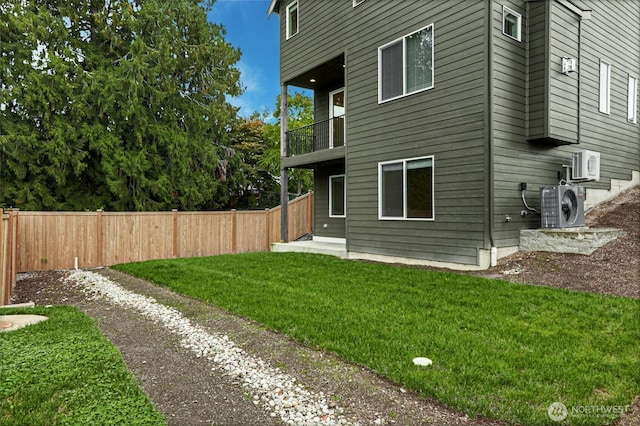 exterior space featuring fence, ac unit, a lawn, a balcony, and driveway