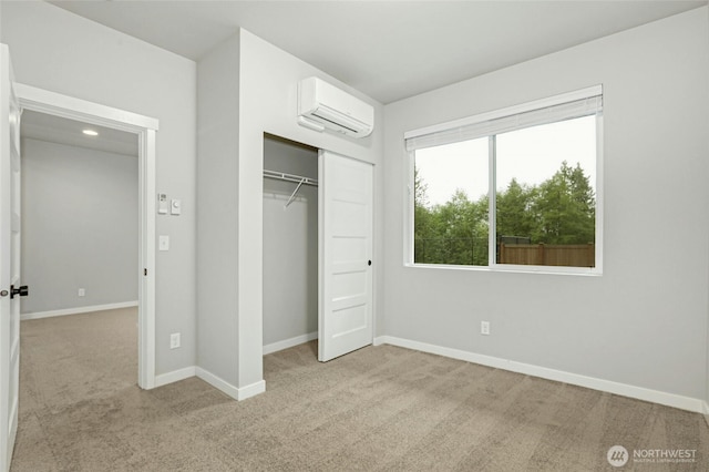 unfurnished bedroom featuring baseboards, carpet floors, and a wall unit AC