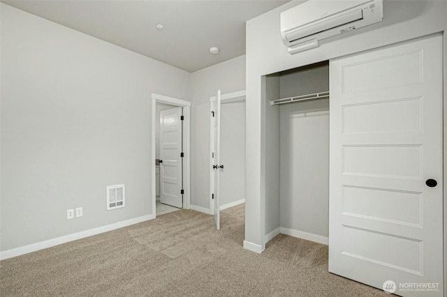 unfurnished bedroom with a wall mounted air conditioner, visible vents, light carpet, a closet, and baseboards