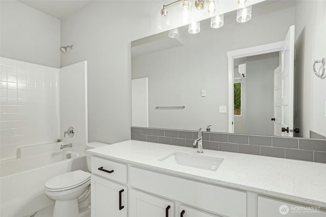 full bath with backsplash, toilet, vanity, and  shower combination