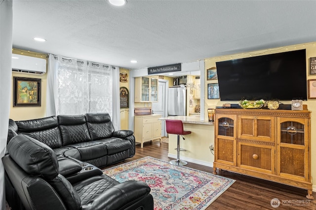 living area featuring dark wood finished floors, recessed lighting, a textured ceiling, and a wall unit AC