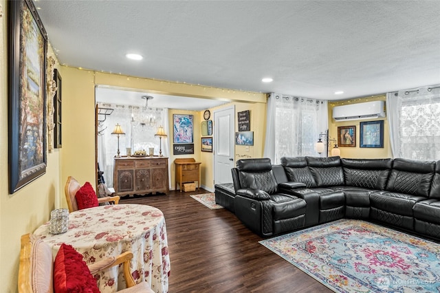 living area with recessed lighting, a textured ceiling, an AC wall unit, and wood finished floors