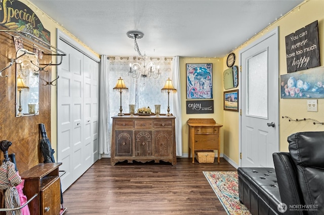 sitting room with an inviting chandelier, wood finished floors, and baseboards