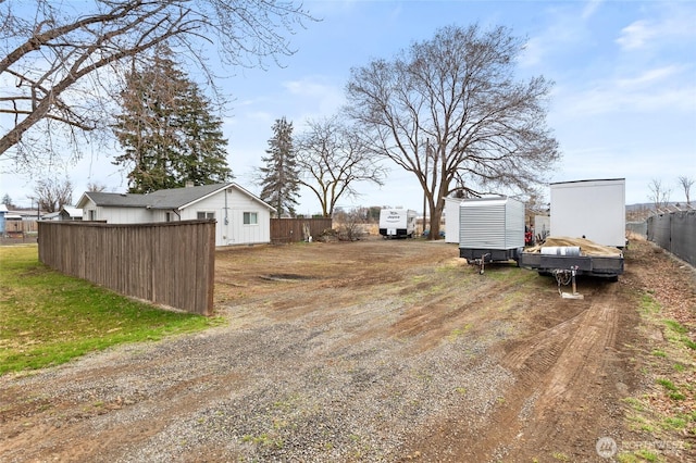 view of yard featuring fence and driveway