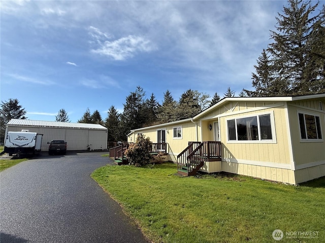 manufactured / mobile home featuring an outdoor structure and a front yard