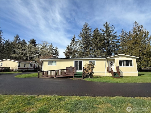 manufactured / mobile home with a deck, a front lawn, and entry steps