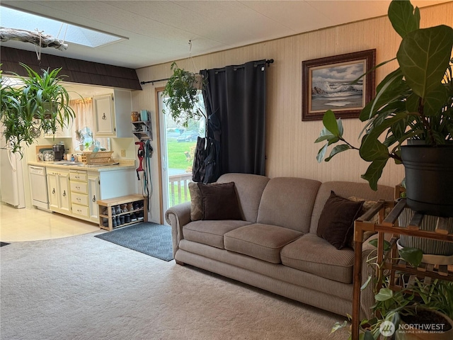 living area featuring light carpet and a skylight