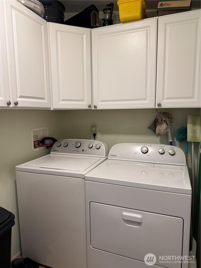 washroom featuring cabinet space and separate washer and dryer