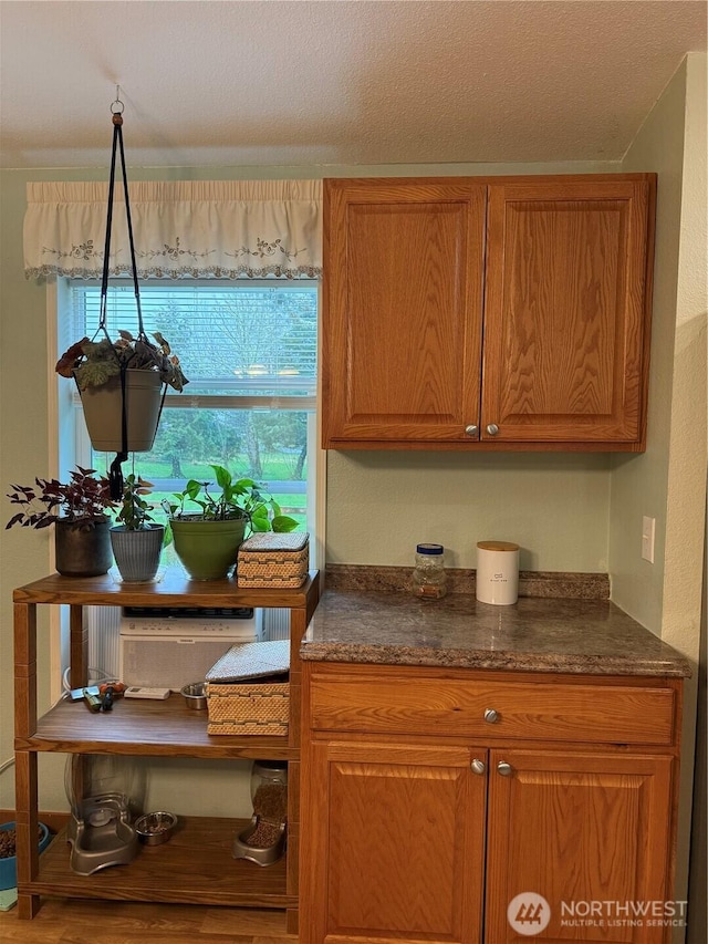 kitchen with dark countertops, brown cabinets, and a textured ceiling