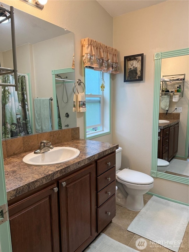 bathroom with vanity, toilet, a shower, and tile patterned flooring