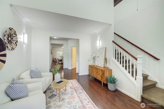 living room with stairway, wood finished floors, baseboards, and ornamental molding