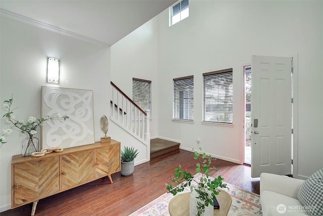 living area featuring visible vents, ornamental molding, stairway, wood-type flooring, and baseboards