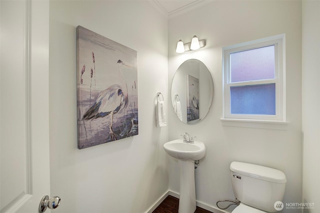 half bath featuring toilet, baseboards, and ornamental molding