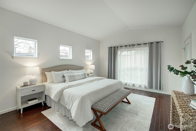 bedroom featuring multiple windows, lofted ceiling, and dark wood-style flooring