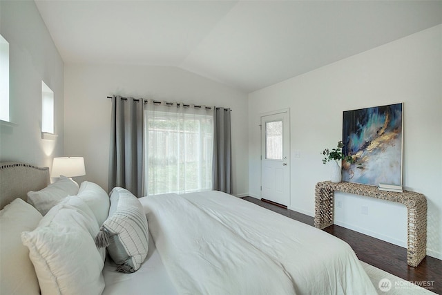 bedroom with lofted ceiling, baseboards, and dark wood-type flooring