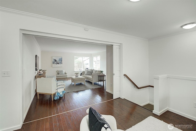 interior space with baseboards, wood-type flooring, and ornamental molding