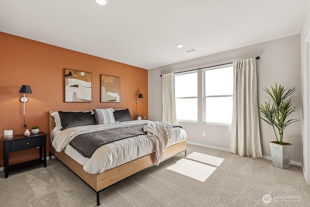 carpeted bedroom featuring baseboards and visible vents