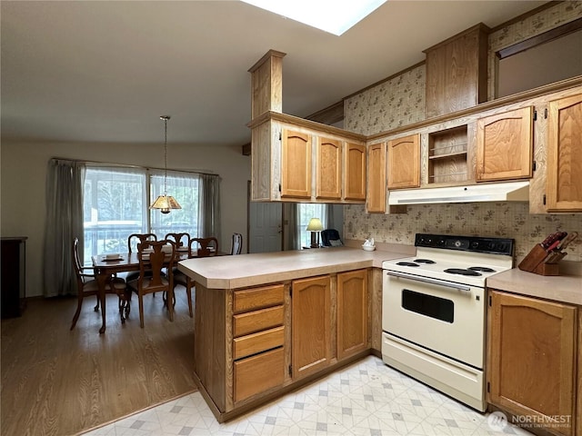 kitchen featuring under cabinet range hood, white range with electric stovetop, a peninsula, light countertops, and light floors