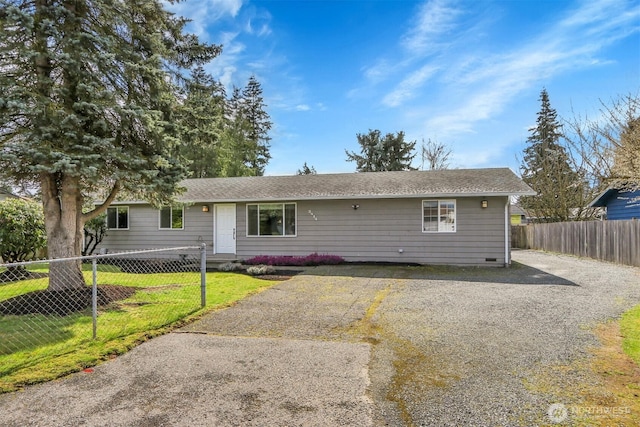 single story home featuring a shingled roof, a front lawn, and fence