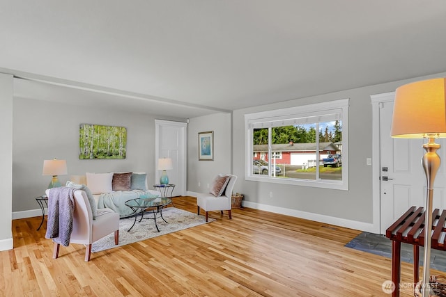 living room with baseboards and light wood-style flooring