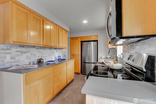 kitchen featuring light brown cabinets, decorative backsplash, recessed lighting, and appliances with stainless steel finishes