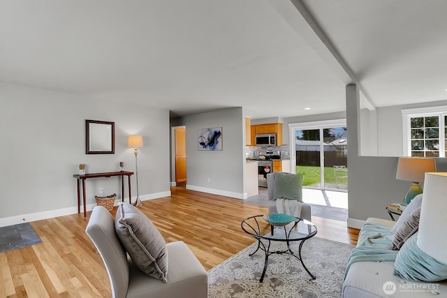 living area with recessed lighting, baseboards, and light wood-type flooring