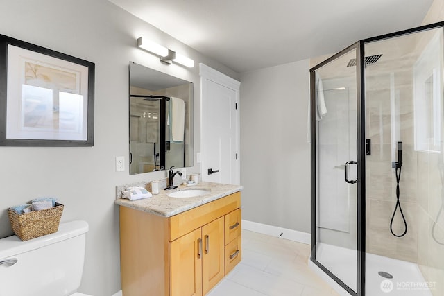 full bath featuring tile patterned flooring, baseboards, toilet, a stall shower, and vanity