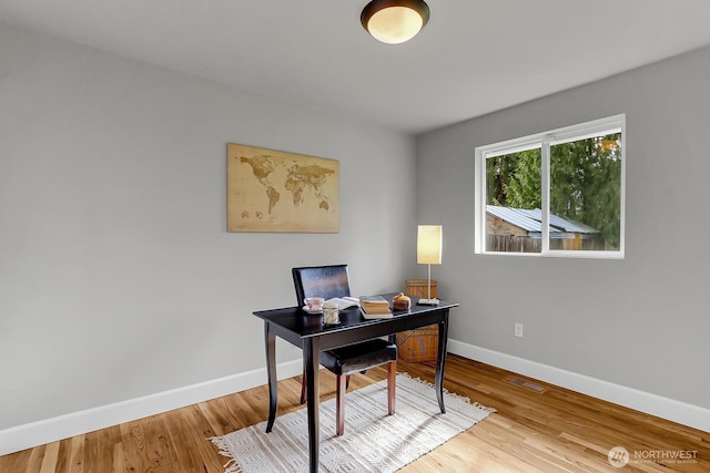 office area with visible vents, wood finished floors, and baseboards