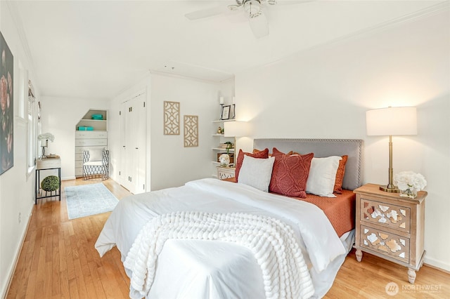 bedroom with baseboards, ornamental molding, a ceiling fan, and light wood finished floors