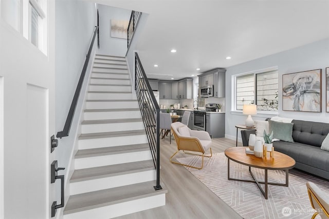 stairs with recessed lighting, baseboards, and wood finished floors