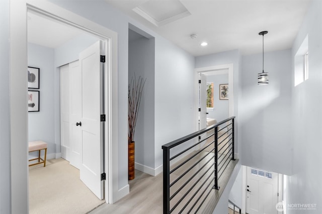 hall featuring visible vents, an upstairs landing, wood finished floors, recessed lighting, and baseboards