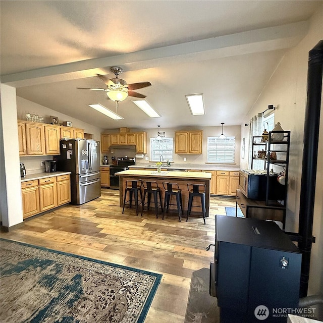 kitchen with lofted ceiling with beams, stainless steel fridge, black range with electric cooktop, and light countertops