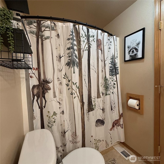 full bath featuring visible vents, curtained shower, toilet, and baseboards