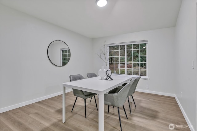 dining area with light wood-style flooring and baseboards