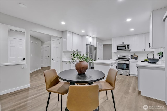 dining area with light wood-type flooring, visible vents, baseboards, and recessed lighting