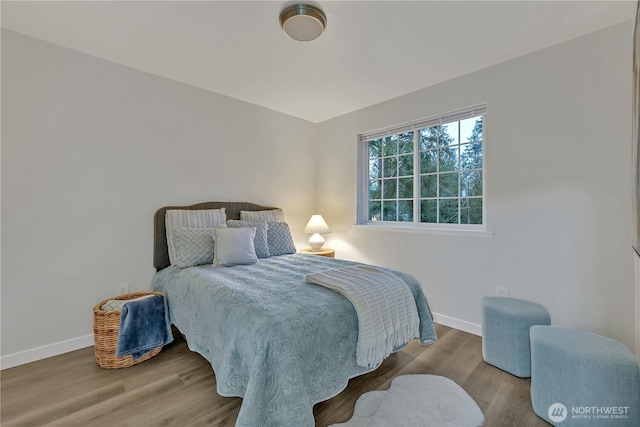 bedroom with baseboards and wood finished floors