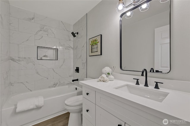 bathroom with shower / bath combination, toilet, wood finished floors, and vanity