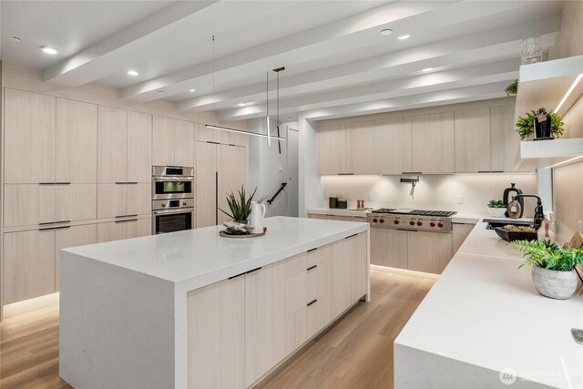 kitchen featuring a large island, appliances with stainless steel finishes, modern cabinets, and a sink