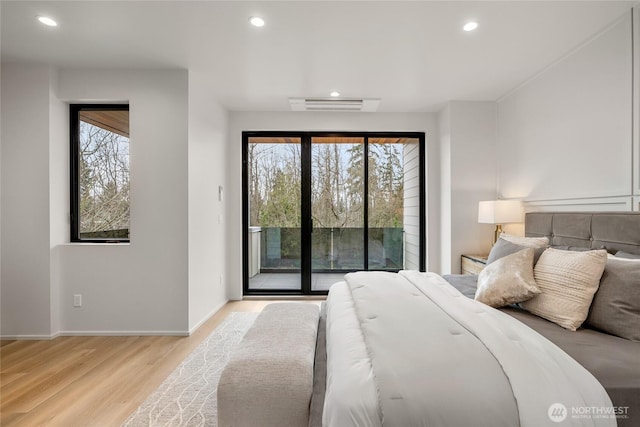 bedroom featuring visible vents, multiple windows, light wood-style flooring, and access to outside