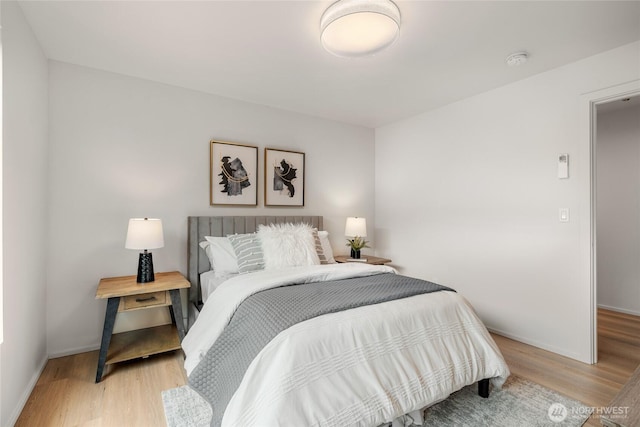 bedroom with light wood-style floors and baseboards